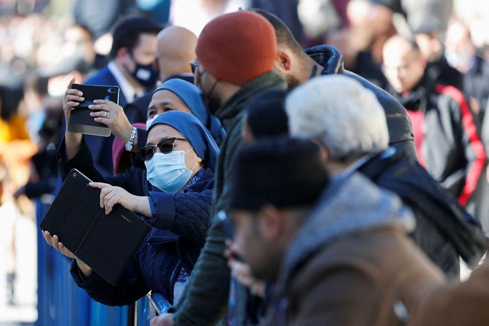 Women take pictures of Greek Orthodox Patriarch of Jerusalem Theophilos III