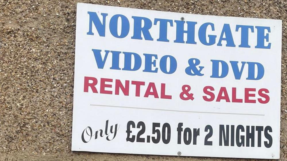 Above a large window is a sign that reads 'Northgate Video and DVD rental and sales. Only £2.50 for two nights'. 