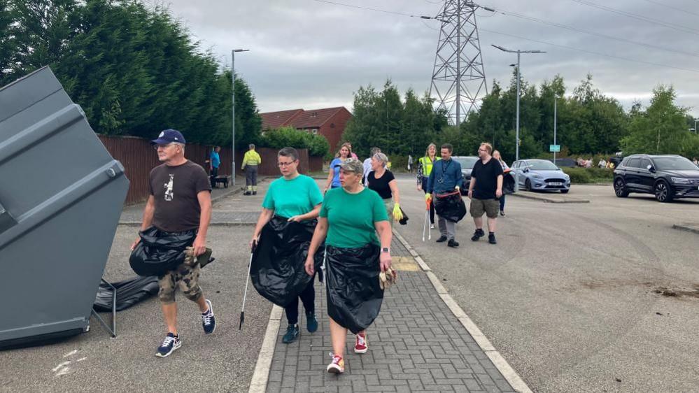 People carrying equipment to start clear up