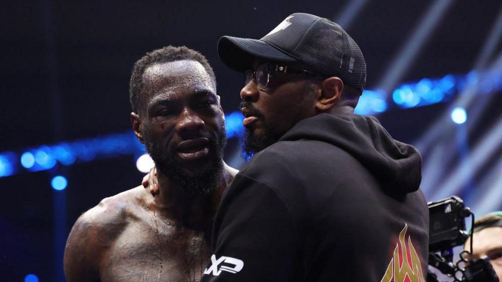 Deontay Wilder being consoled by trainer Malik Scott after a defeat 