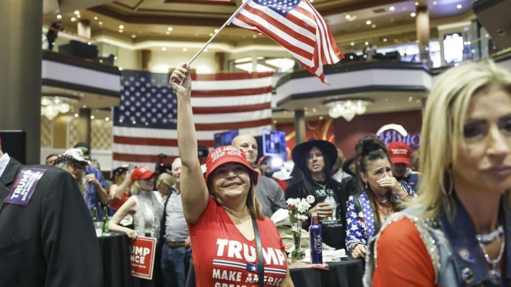 People react to election results showing US Republican presidential candidate Donald J. Trump's lead in the state of Nevada during the Nevada Republican Party watch party at the Ahern Hotel in Las Vegas, Nevada