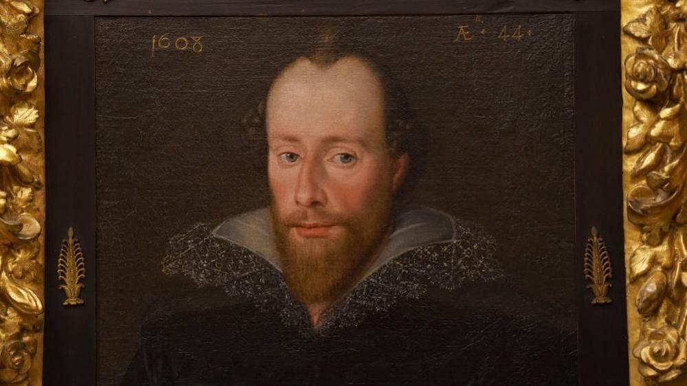 A portrait of William Shakespeare shows him looking thoughtfully at the viewer, with a thick beard. The painting, which sits in a gold leaf frame, is dated 1608.