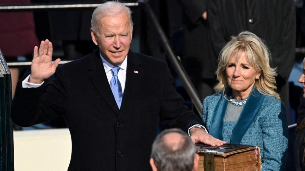 Joe Biden takes the oath of office as Jill Biden holds his bible