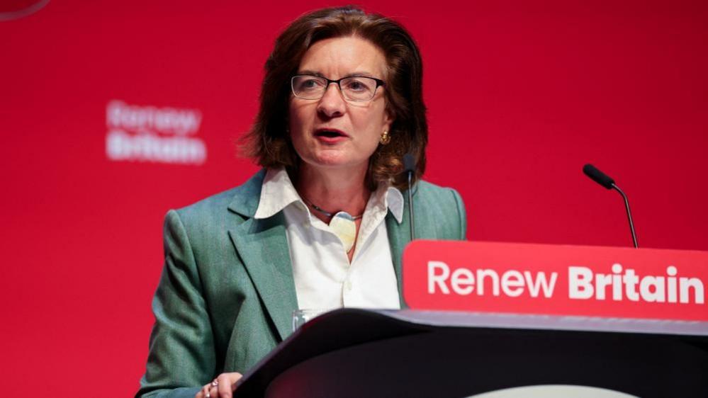 First Minister Eluned Morgan gives a speech from a lectern at the Labour Party conference. The lectern has a sign with slogan that reads "Renew Britain".