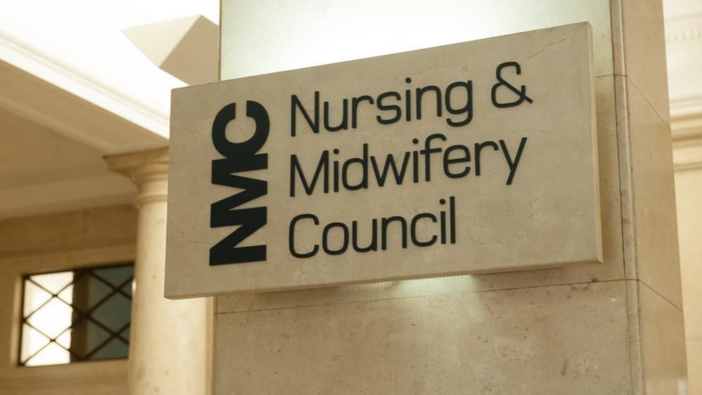 Nursing and Midwifery Council sign in black writing on a stone plinth and stone wall.