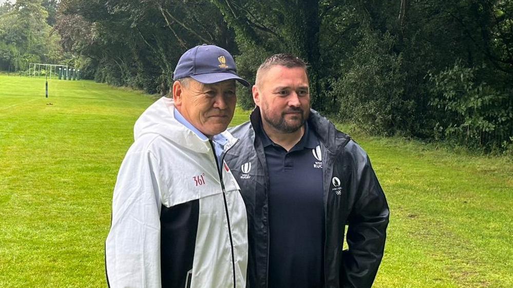 Nurgazy Kuldzhaev (left) and Greg Woods (right) embrace for a pre-match photo.