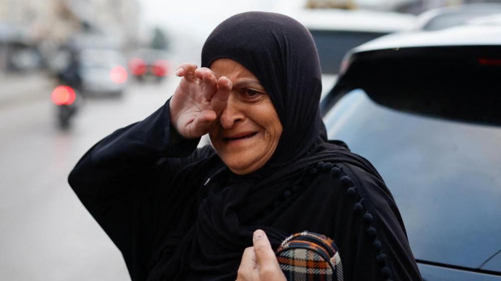 A woman cries after returning to her city, after a ceasefire between Israel and Iran-backed group Hezbollah took effect at 0200 GMT.