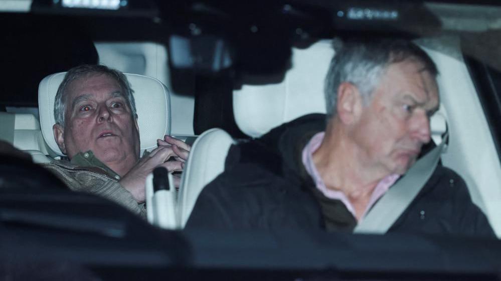 Ish-princi Andrew në pjesën e pasme të një makine pas lirimit të tij, me një shprehje tronditjeje në fytyrën e tij.