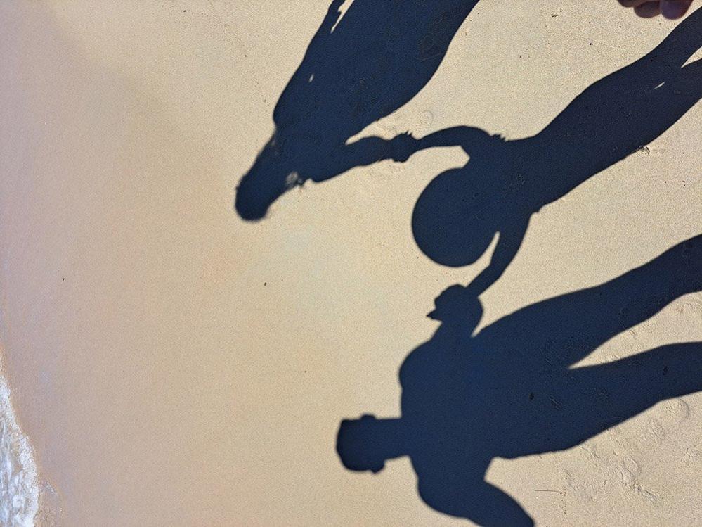 Shadow of family on sand