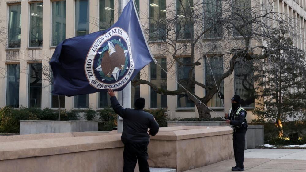 The flag of the Office of Personnel Management is lowered outside its Washington headquarters.