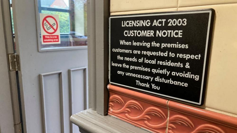 A notice on the wall of the pub, asking people to leave quietly.