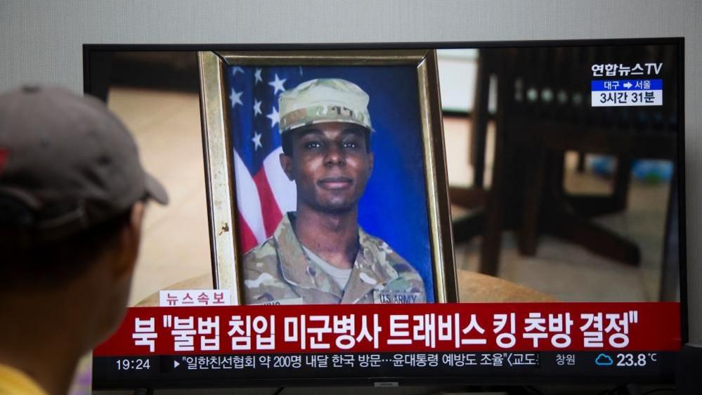 A man watches the news showing US soldier Travis King on screen, at a his home in Seoul, South Korea