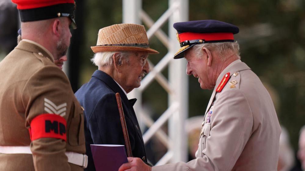 Britain's King Charles talks to Yavar Abbas as they attend a Service of Remembrance at the National Memorial Arboretum to commemorate the 80th Anniversary of VJ Day 
