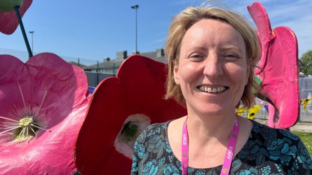 Dr Catherine Richards standing by a giant flower