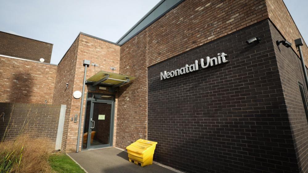 A brown brick building with the words 'Neonatal Unit' on the side. 