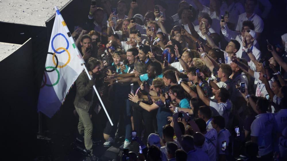 Tom Cruise is mobbed by athletes in the Stade de France