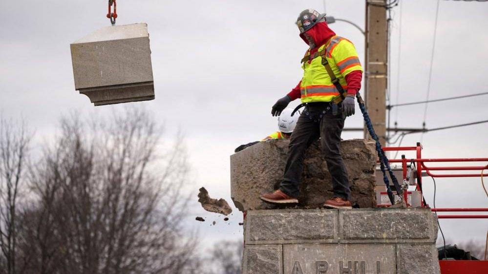 A worker removing the statue