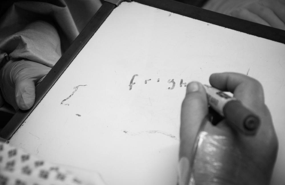 A member of staff writing on a white board