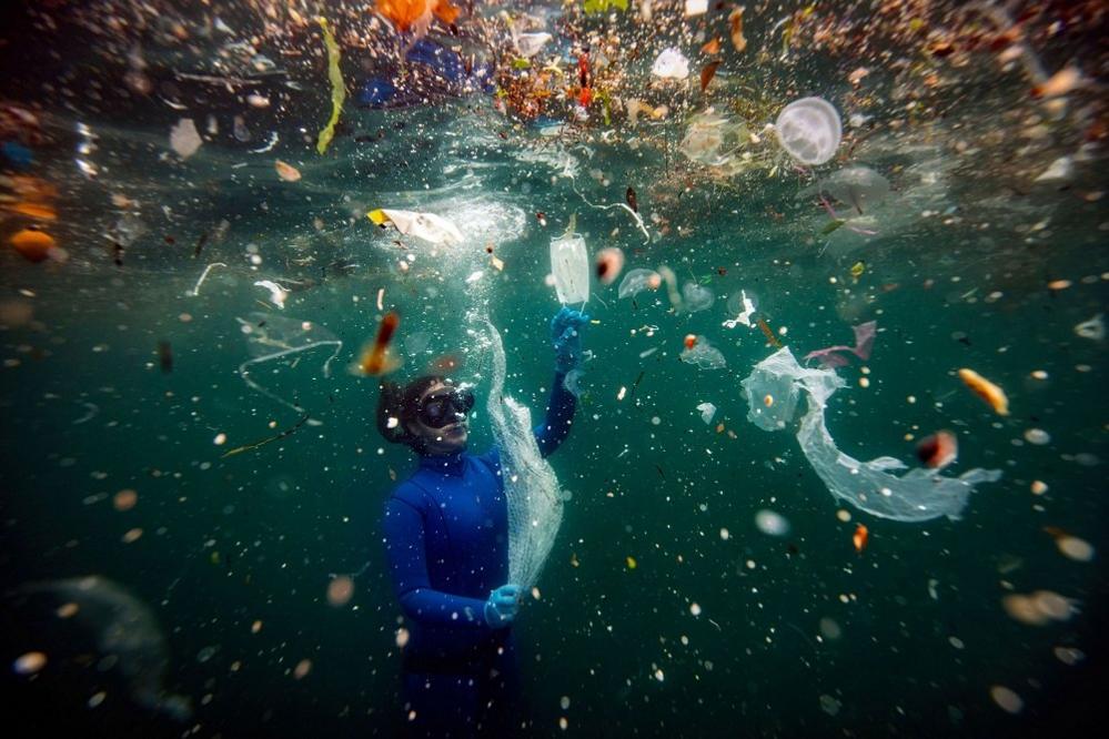 woman-in-water-surrounded-by-rubbish.