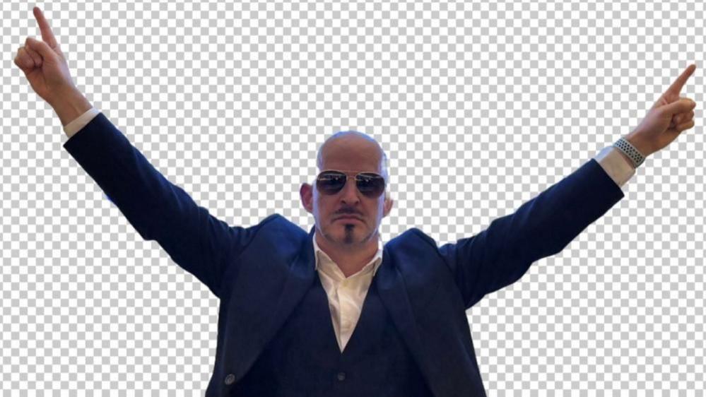 Phil Mansford, dressed like Pitbull, in a dark blue suit, with a waistcoat, white shirt, shades on and dark goatee beard.