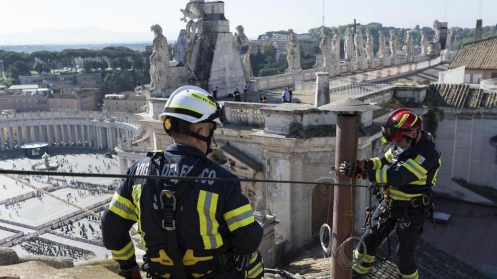 Images show firefighters installing the chimney atop the Sistine Chapel in Vatican City on 2 May 2025