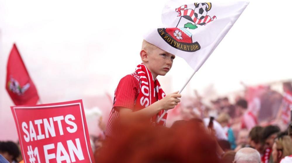 Boy in crown waving Southampton FC flag