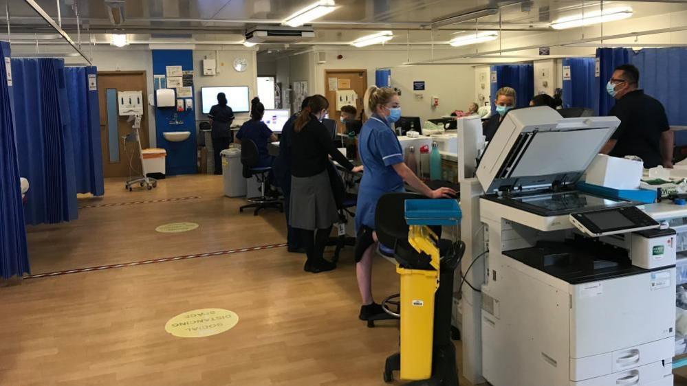 Hospital ward with nurses and cubicles visible