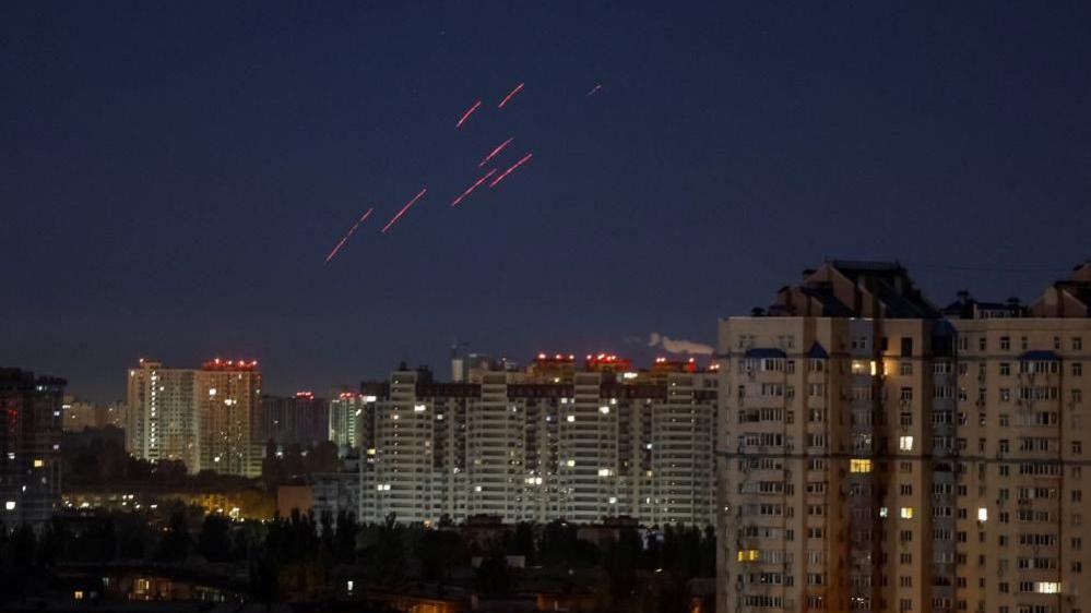 Tracers are seen in the night sky as Ukrainian servicemen fire at a drone over Kyiv, Ukraine, October 21, 2024. 