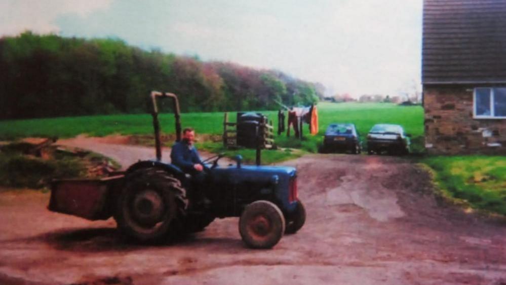 Handout photo showing John Charlesworth driving a blue tractor.