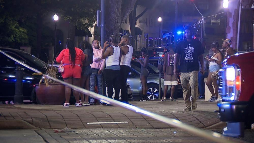 People stand by the scene of a mass shooting in Birmingham, Alabama