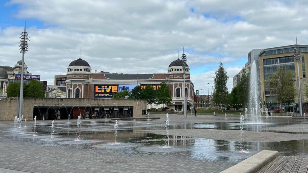 Fountains on a paved square, with the Bradford Live entertainment venue in the background.
