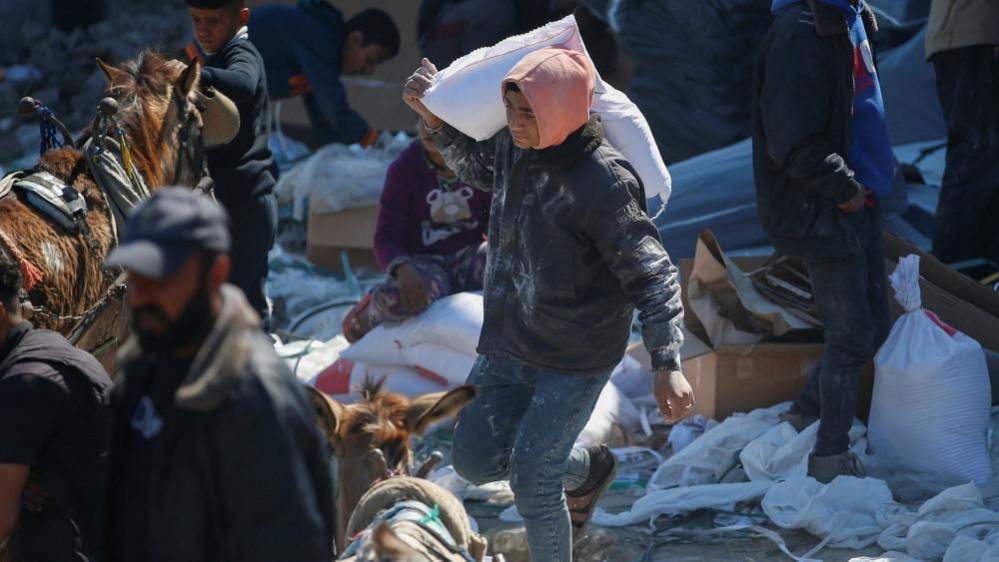 A Palestinian boy carries a bag with aid supply provided by the UN's Palestinian refugee agency (Unrwa) in northern Gaza Strip. Photo: 2 March 2025