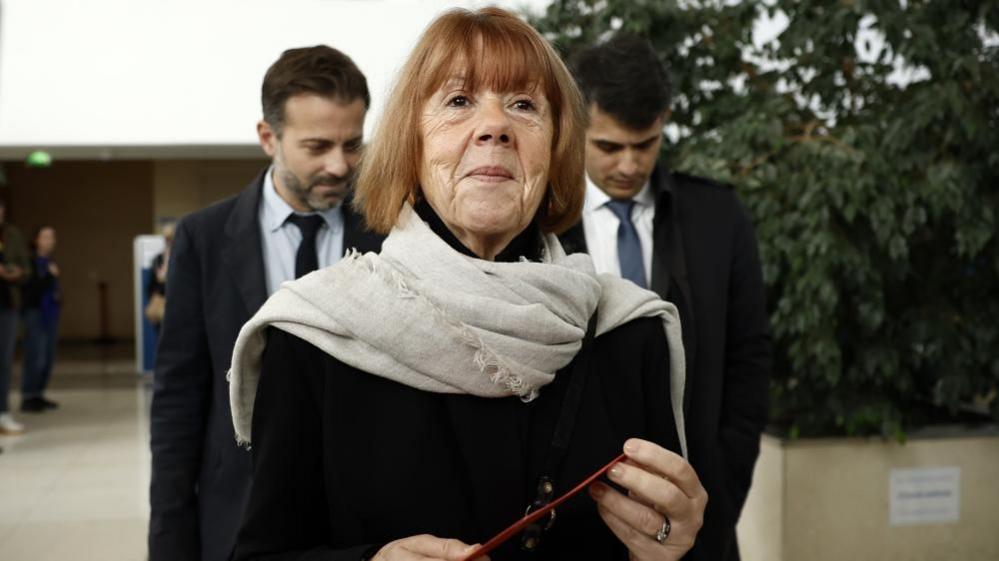 Gisèle seen walking down a road