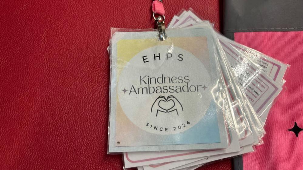 A lanyard with Kindness Ambassador written on it