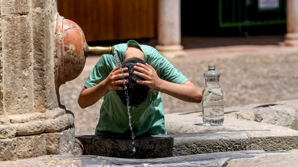 Tourist cooling off in fountain in Cordoba, Spain on 22 June 2026
