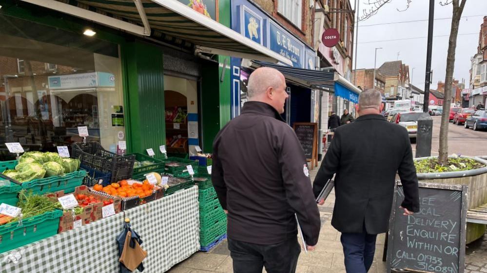 Two men walking down Rushden High Street