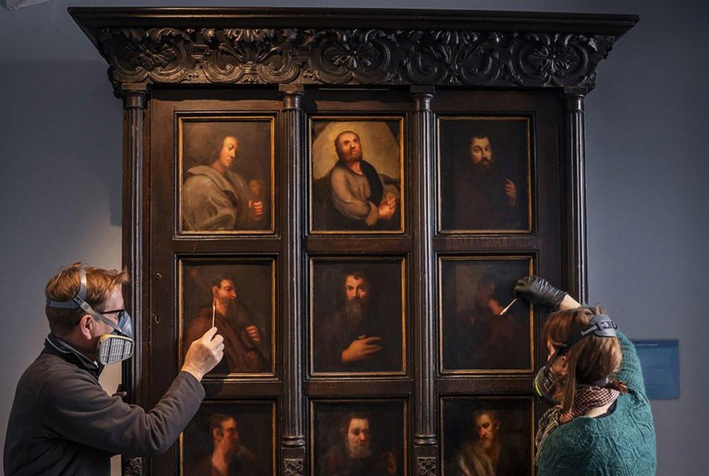 Conservators David Everingham and Alison Aynesworth work to restore 12 oil-painted panels on the Apostle's Cupboard on display at the Bronte Parsonage Museum in Haworth, 6 November 2023