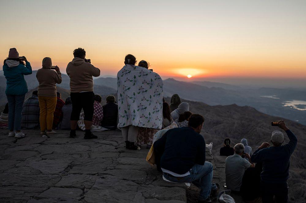 People watch the sunrise on a mountain in Turkey