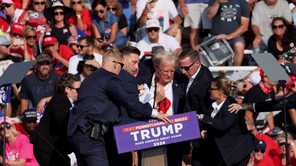 Trump protected by Secret Service agents at rally after shooting