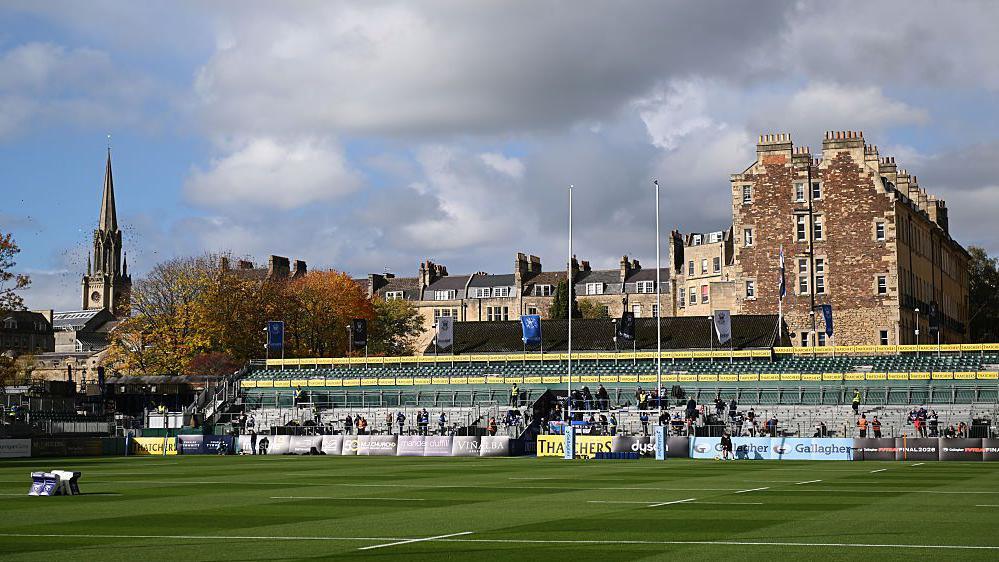 The Rec pitch with a picturesque view of housing and church spire behind the stand