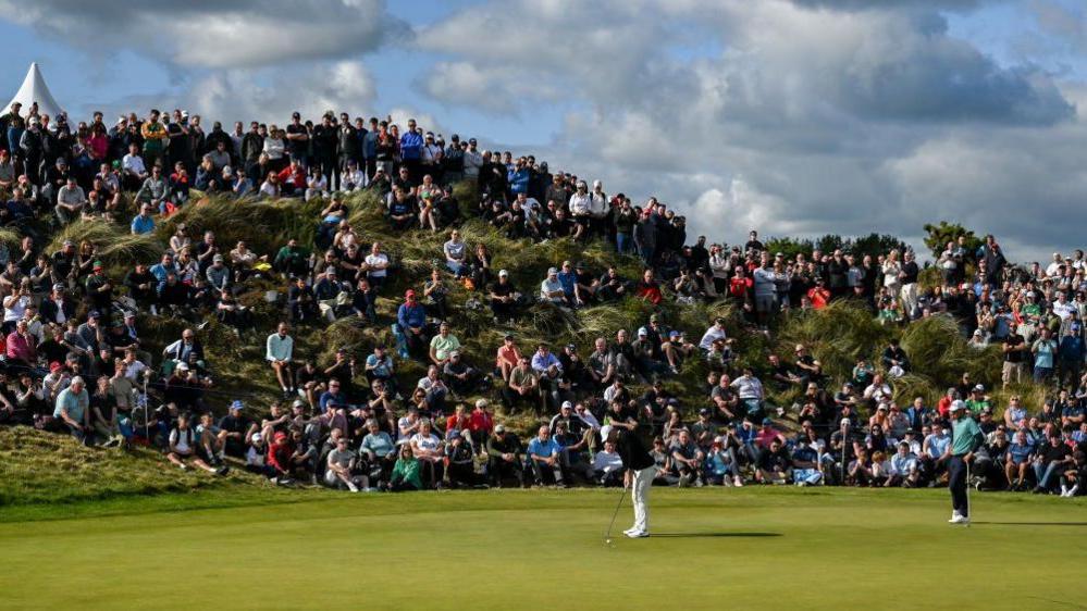 The crowd watches McIlroy putt during the final round