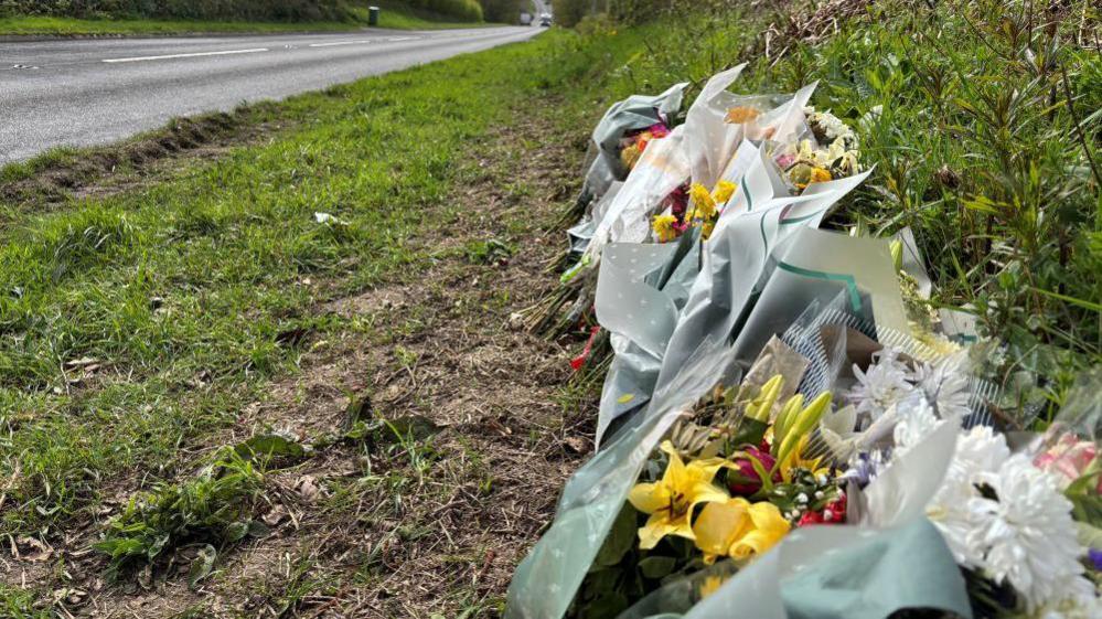 Mae nifer wedi gadael blodau ar safle'r gwrthdrawiad