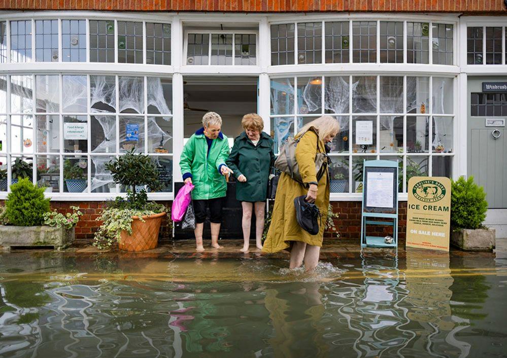 Women wade through floodwater in Bosham