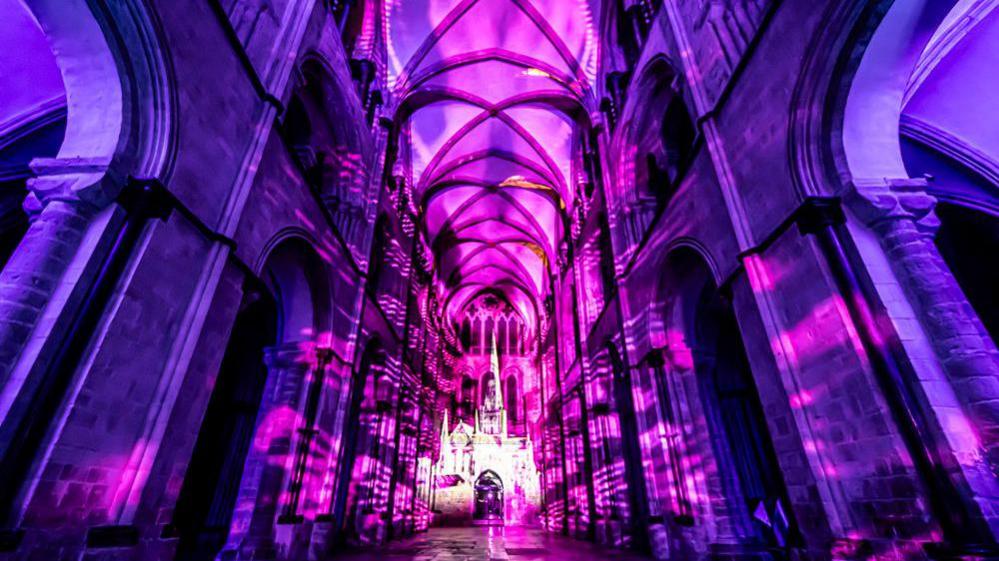 A purple and black light show inside Chichester Cathedral.