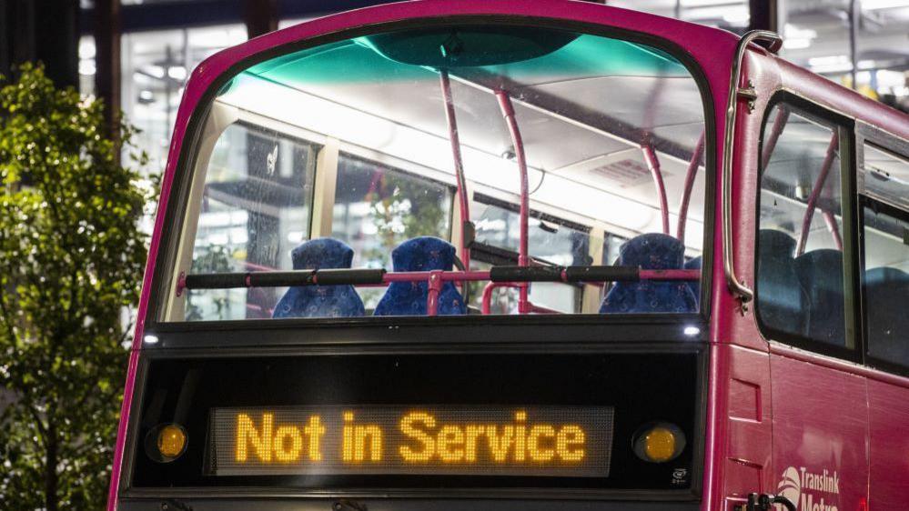 Pink Metro bus in the dark displaying 'Not in Service'