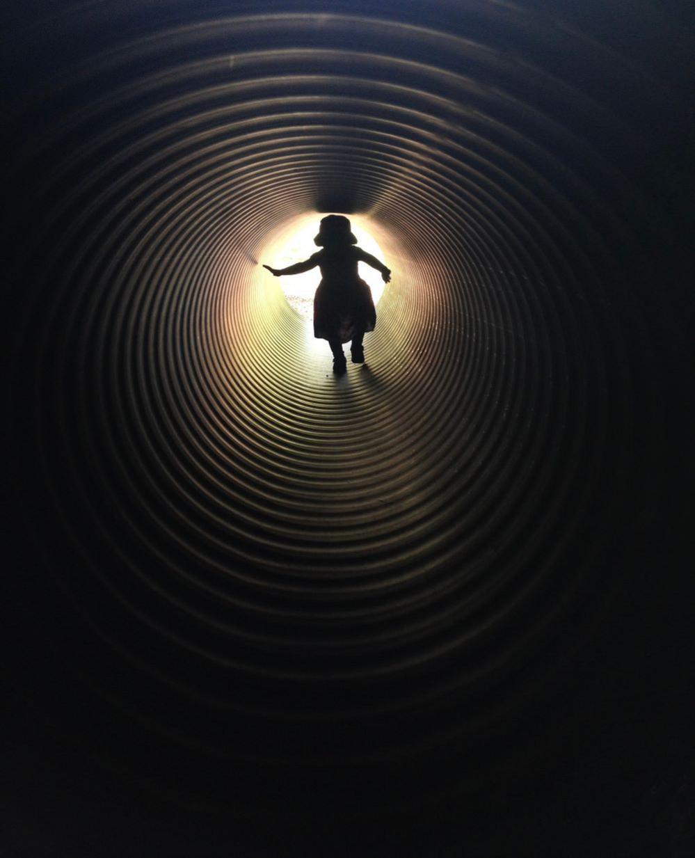 The silhouette of a girl in a tunnel