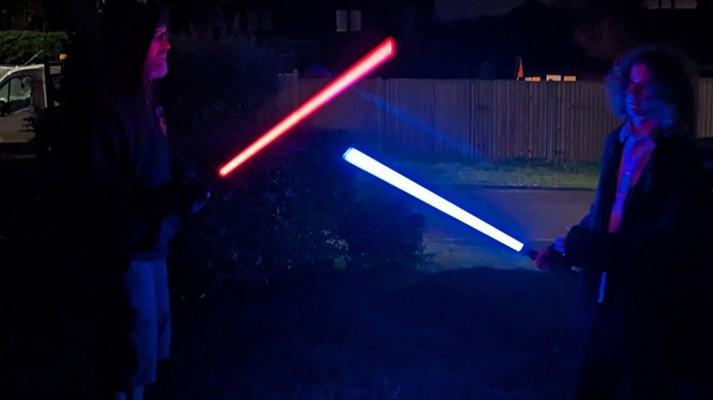 Two people with lightsabres