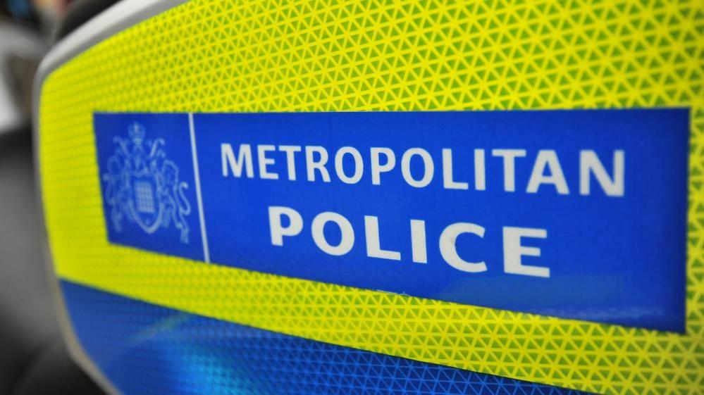 A yellow and blue sign containing the white words "METROPOLITAN POLICE"