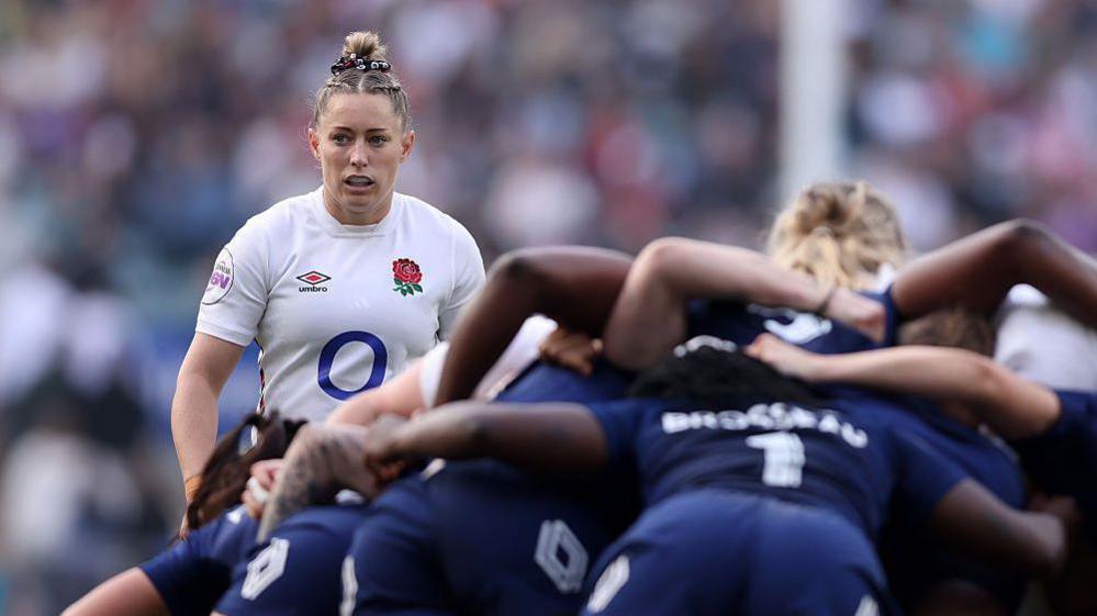 Natasha hunt looking over a scrum of French players in the 2025 six nations tournament.