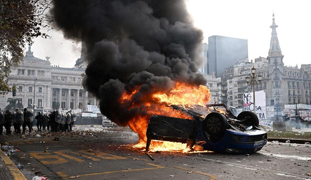 A car burns during a protest near the National Congress in Buenos Aires on 12 June